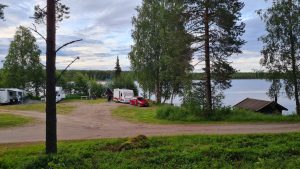 Ett par husvagnar, en grillplats och bastun till höger. 